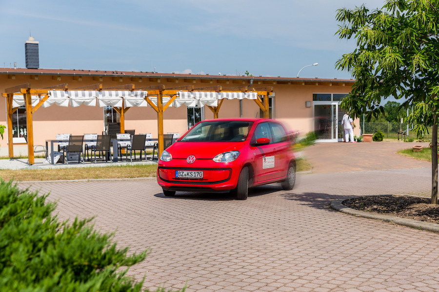 Fahrzeug der Tagespflege vor dem Haus mit Terrasse